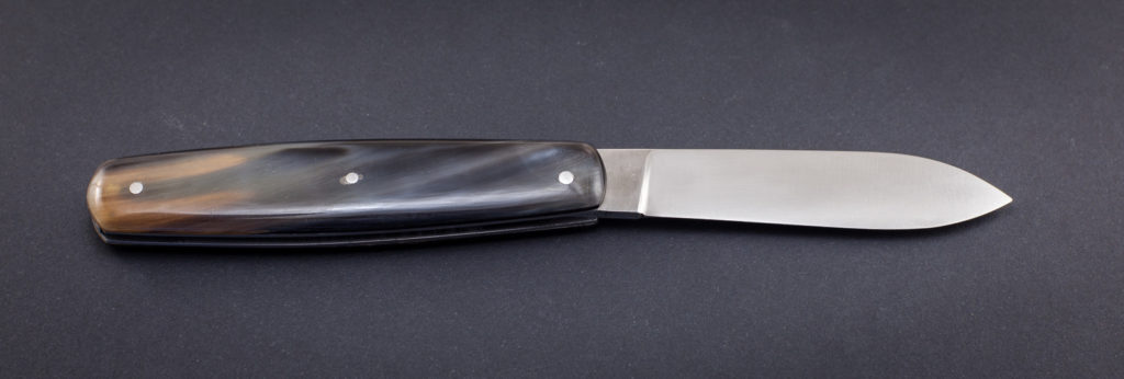 couteau de poche pliant artisanal cran plat, manche corne de zébu, lame pointe centrée inox (modèle navette nogentaise)