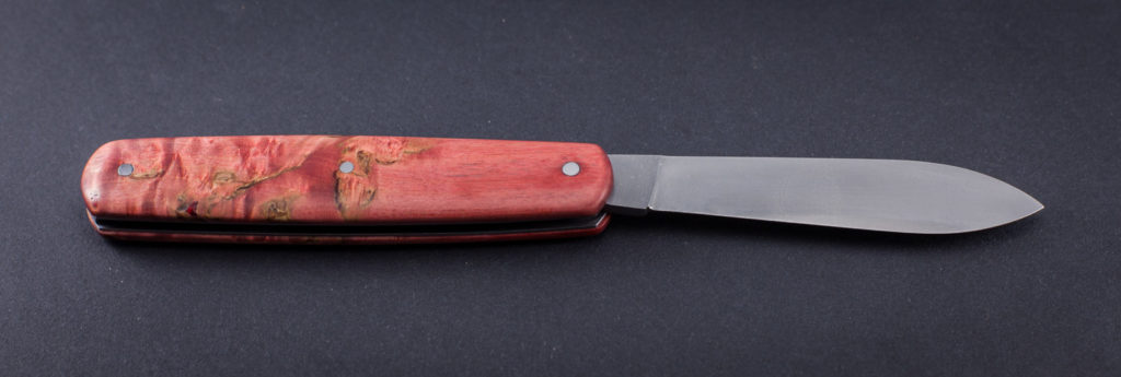 couteau de poche pliant artisanal cran plat, manche bouleau de Carélie rouge, lame pointe centrée inox (modèle calypso)